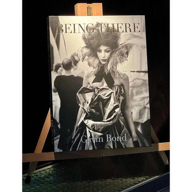Book cover of 'Being There' by Gavin Bond featuring a black and white portrait of a fashion model with elaborate feathered collar.