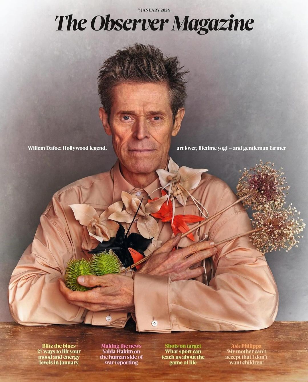 The Observer Magazine cover featuring Willem Dafoe in a light-pink shirt, surrounded by natural elements like flowers and seed pods.