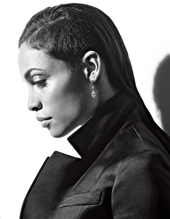 Monochrome portrait of a woman in profile wearing a dark blazer and drop earrings against a bright background by Gavin Bond.