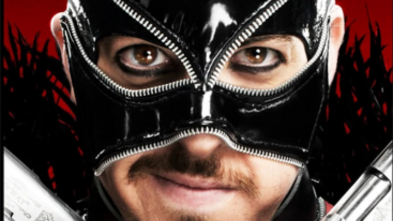 Close-up of a male adult wearing a black zipper mask, facial hair, and holding silver handguns against a red and black background.