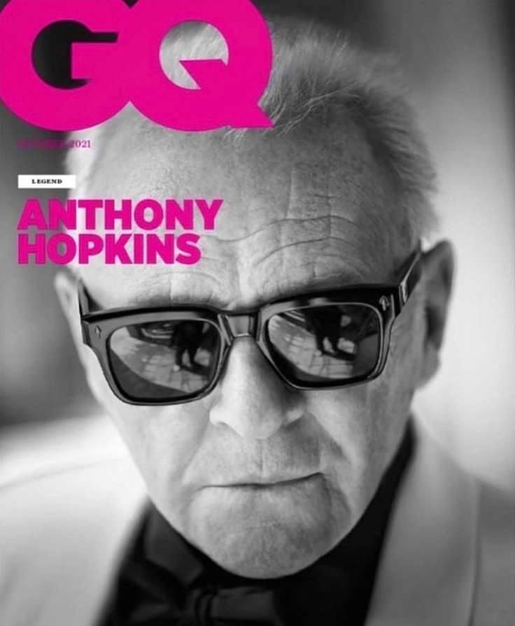Black and white portrait of Anthony Hopkins on GQ magazine cover, October 2021. He wears sunglasses, bow tie, and jacket.
