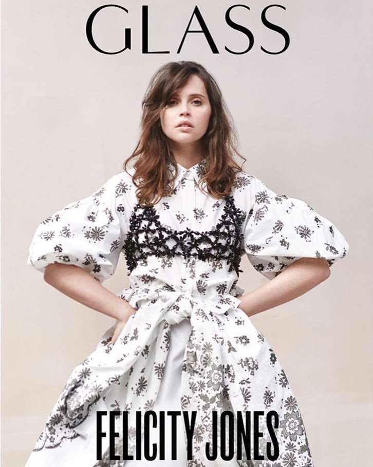 Felicity Jones on the cover of Glass magazine wearing a white dress with black floral print with a dark net-like bodice.
