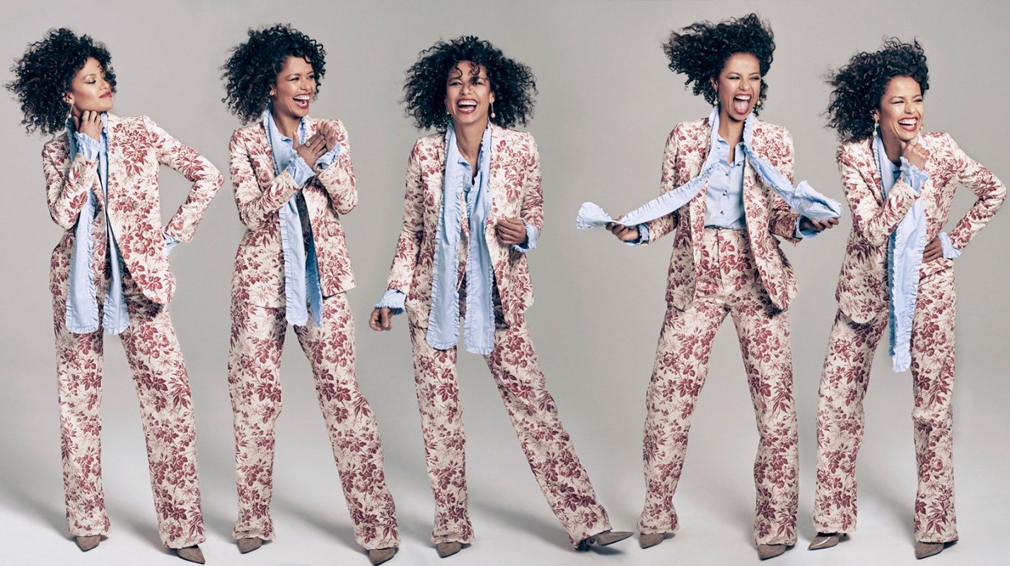 Five sequential poses of a laughing woman wearing a red floral print suit and light blue ruffled shirt against a grey studio backdrop.