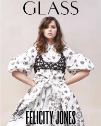 Felicity Jones wearing a white floral dress with a black lace bustier against a pale background