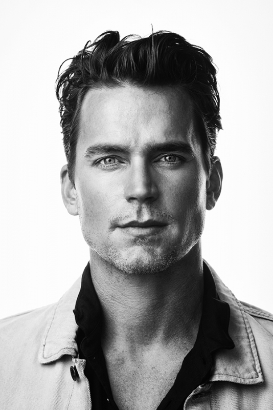 Black and white headshot of an adult male with blue eyes, medium brown hair, wearing a light-colored collared shirt and a dark collared shirt.