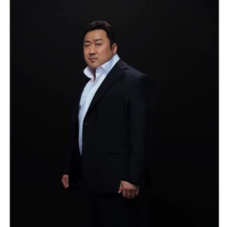 Portrait of Don Lee wearing a black suit and white shirt against a dark background
