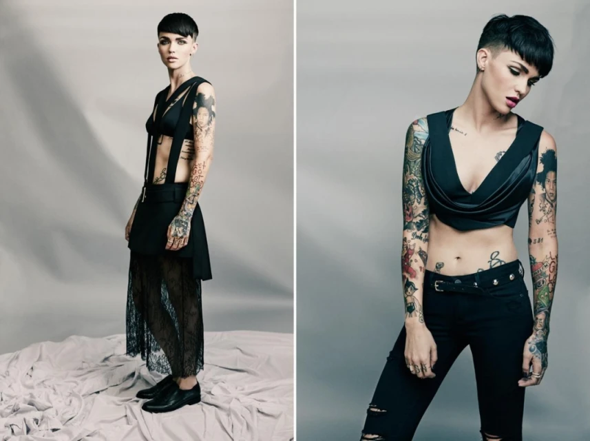 Two shots of Ruby Rose in black apparel, featuring a crop top and skirt, against a plain background, showcasing tattoos and short hair.