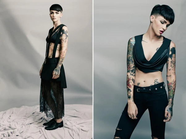 Two shots of Ruby Rose in black apparel, featuring a crop top and skirt, against a plain background, showcasing tattoos and short hair.