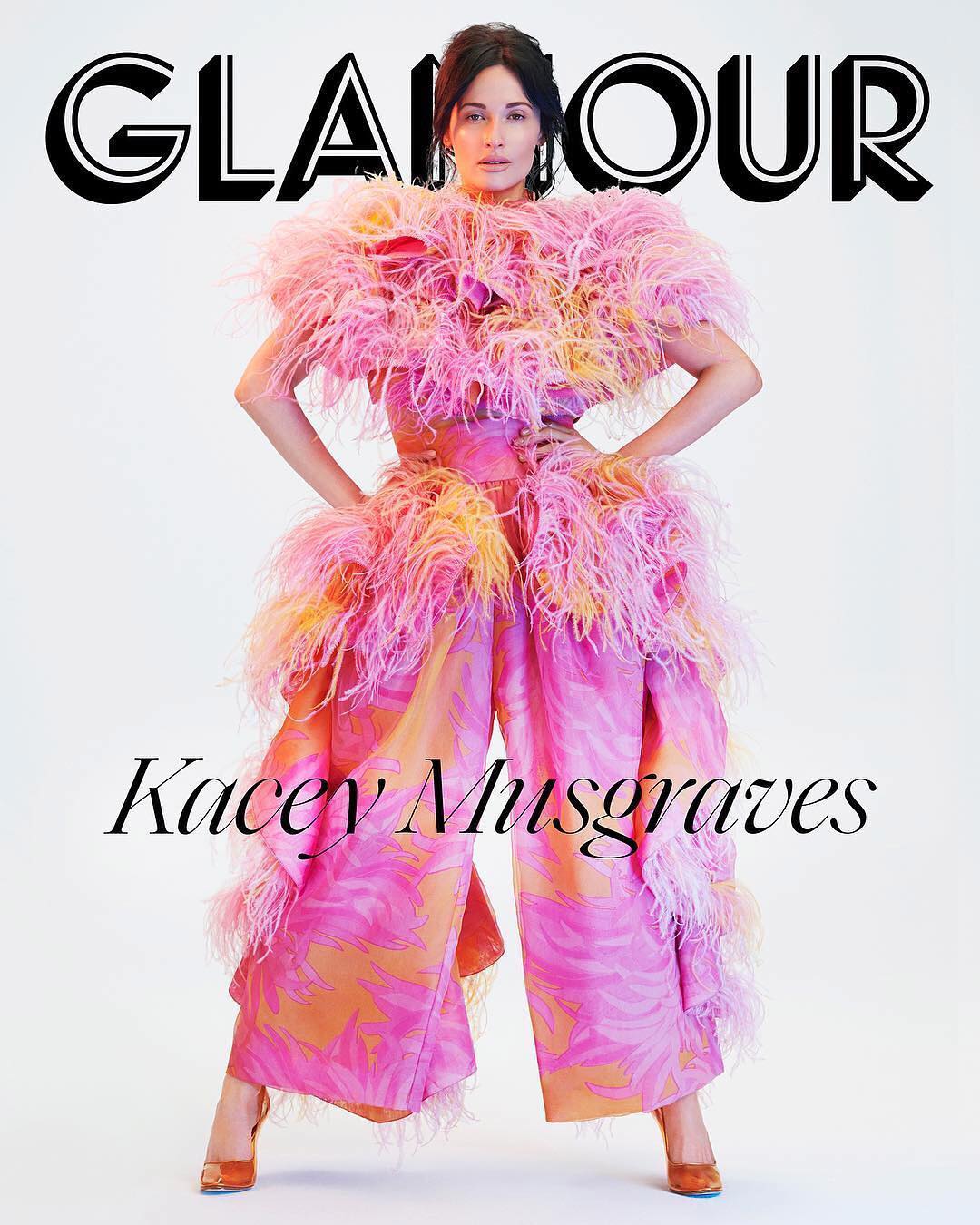 Glamour magazine cover featuring Kacey Musgraves in a pink feathered outfit, posing in a studio setting. Magazine title is visible.