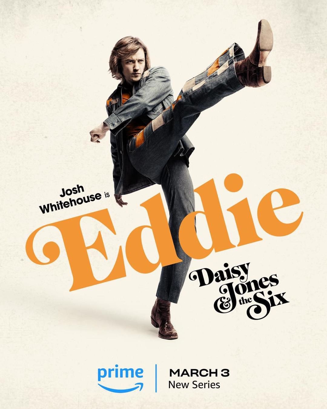 Promotional image for Daisy Jones & The Six featuring Josh Whitehouse as Eddie, wearing a denim jacket and pants, kicking one leg up.