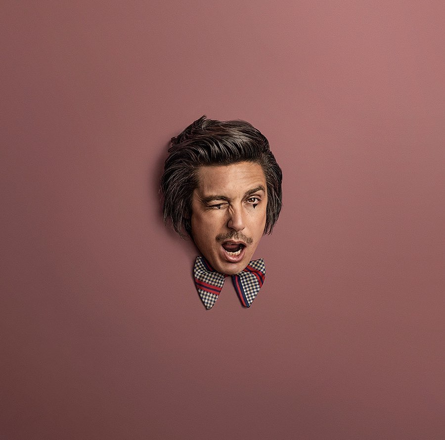 Man with heart eye makeup, winking, wearing bow tie against a pink background. Portrait conveys humor and unique personal style.