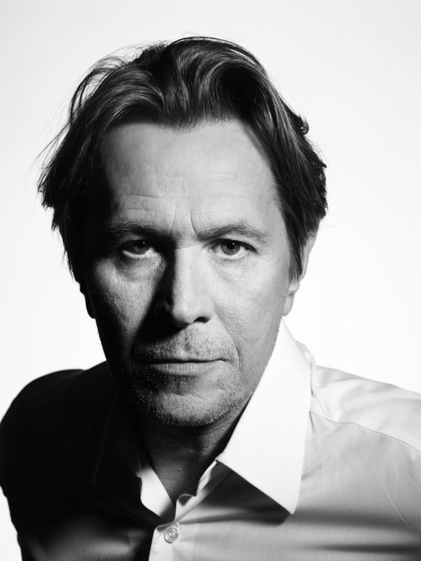 Black and white portrait of an adult male with medium-length hair, wearing a collared shirt against a plain background in a studio setting.
