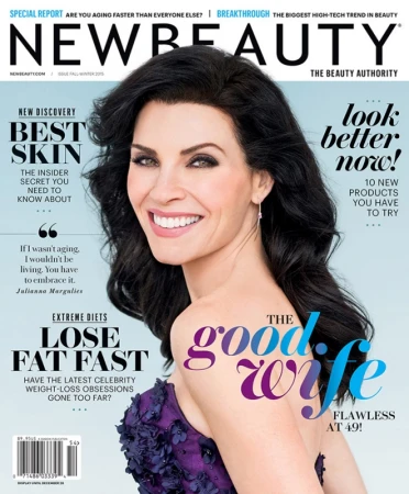 Julianna Margulies smiling on NewBeauty magazine cover wearing a purple floral embroidered dress