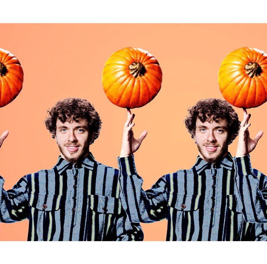 Man in striped shirt balances pumpkins on fingers against peach background, creating a playful and festive visual.