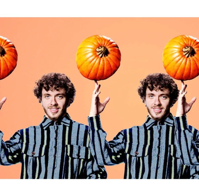 Man in striped shirt balances pumpkins on fingers against peach background, creating a playful and festive visual.