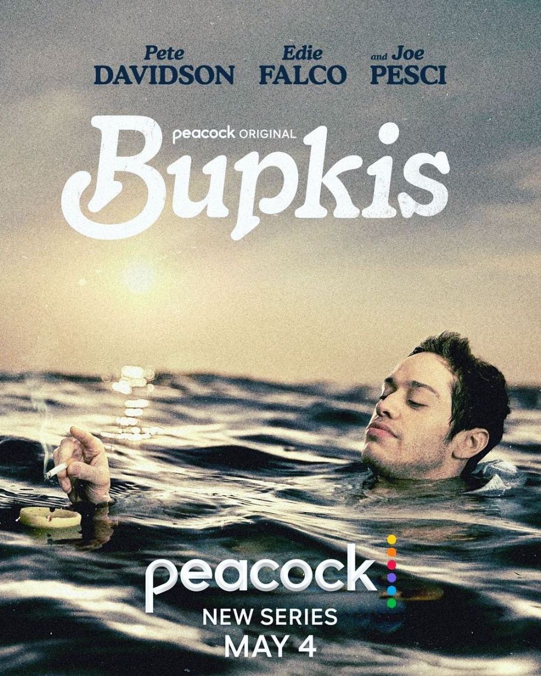 Poster for 'Bupkis' series features Pete Davidson in water with a cigarette, the sun reflecting on waves in the distance.