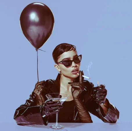 Zoe Kravitz holding a dark balloon and cigarette with a martini glass, photographed by Mary Ellen Matthews.