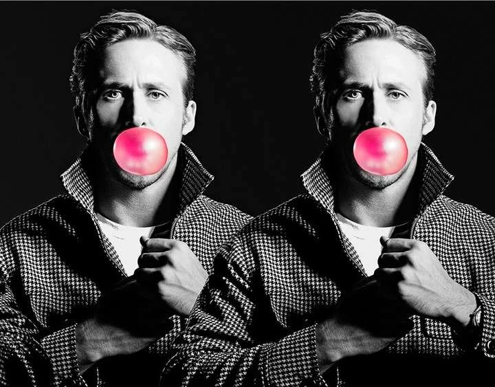 Black and white portrait of two adult men blowing pink bubblegum bubbles, wearing checkered jackets against a dark background.