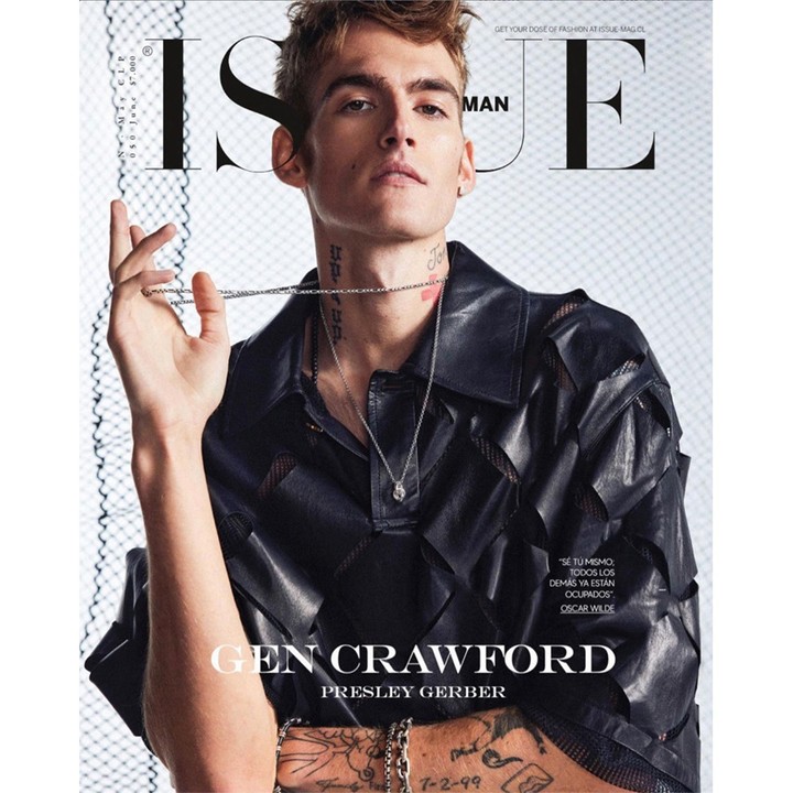 Magazine cover featuring a young male adult with light brown hair in a black leather shirt holding a silver chain necklace.