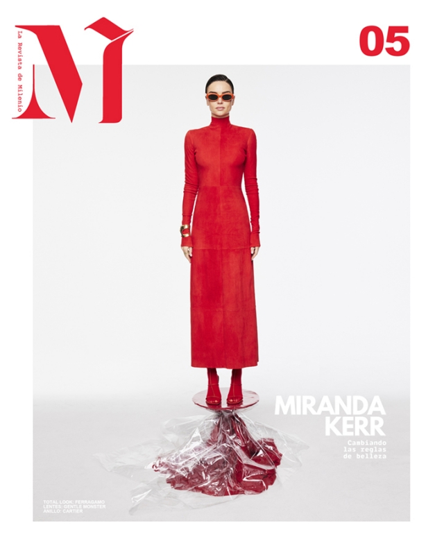 Fashion magazine cover featuring a woman in a red dress and sunglasses, standing on a clear platform with red liquid.