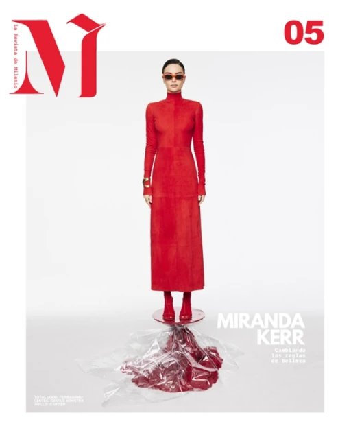 Fashion magazine cover featuring a woman in a red dress and sunglasses, standing on a clear platform with red liquid.