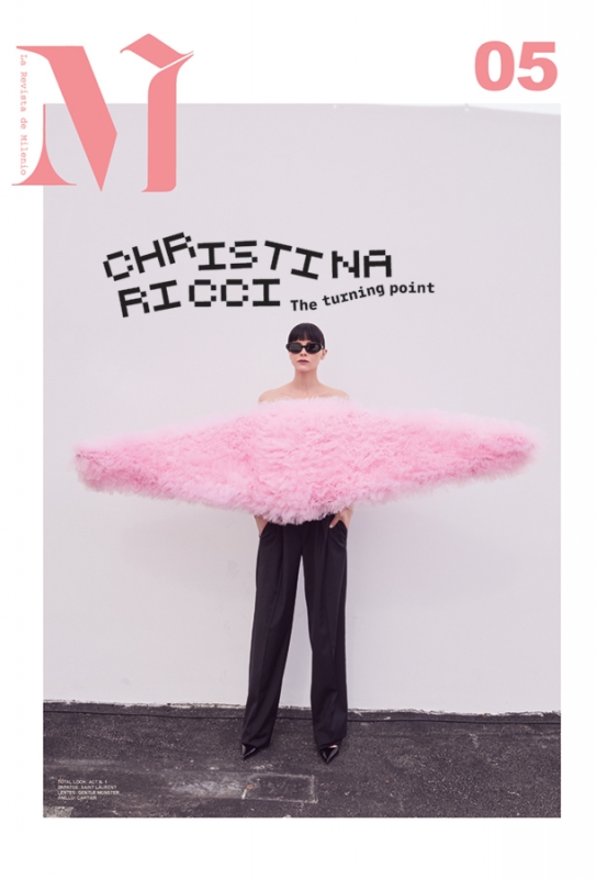 Magazine cover shot of Christina Ricci in pink tulle. Black pixelated font, black pants, and black patent leather shoes, with white background.