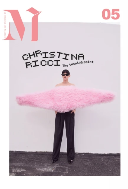 Magazine cover shot of Christina Ricci in pink tulle. Black pixelated font, black pants, and black patent leather shoes, with white background.