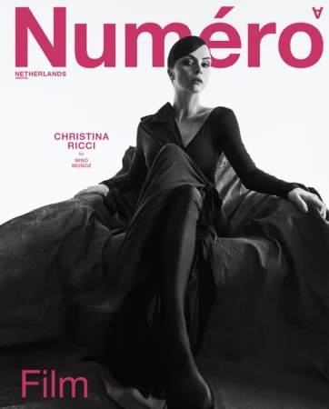 Magazine cover featuring Christina Ricci in a long black dress, seated against a textured gray background with pink 'Numéro' title text.