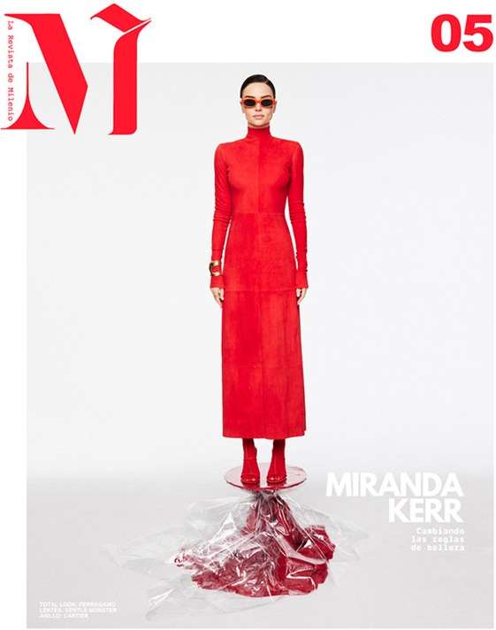 Fashion magazine cover featuring Miranda Kerr in a red turtleneck dress and red boots against a bright, neutral background with minimal props.