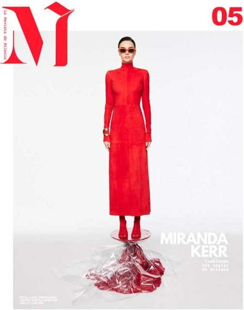 Fashion magazine cover featuring Miranda Kerr in a red turtleneck dress and red boots against a bright, neutral background with minimal props.