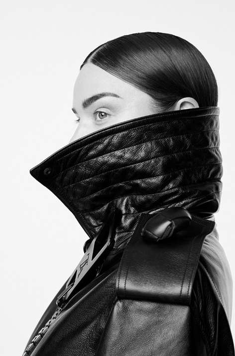 Monochrome headshot of a woman with sleek hair, wearing a black quilted leather jacket with a high collar against a bright white backdrop.