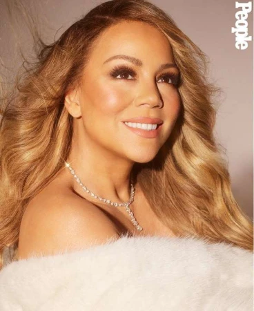 Close-up portrait of Mariah Carey with long blonde wavy hair, wearing a diamond necklace and white fur stole for People magazine.