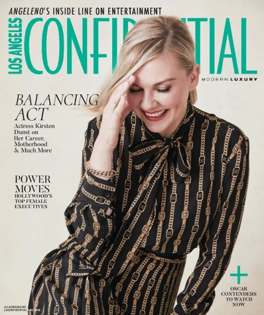 Kirsten Dunst graces the cover of Los Angeles Confidential magazine, smiling in a chain-patterned dress. Modern luxury celebrity fashion.