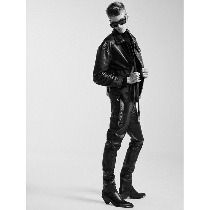 Man wearing dark sunglasses and a black leather jacket against a seamless light background
