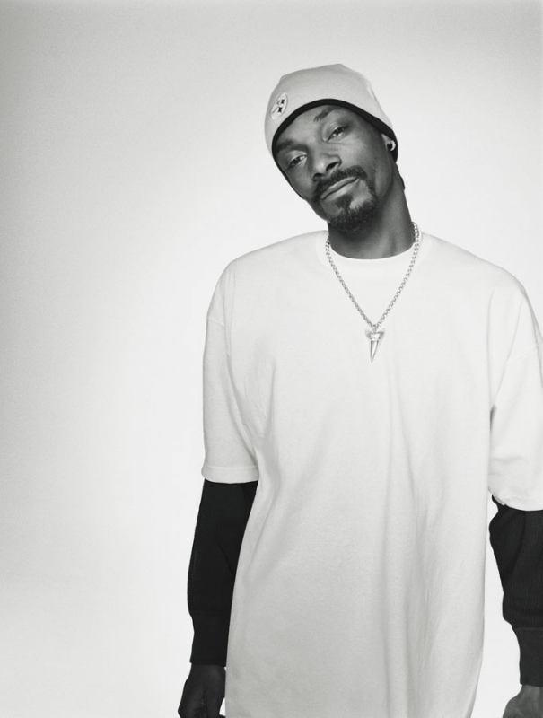Monochromatic portrait of Snoop Dogg wearing a beanie and a white t-shirt with a silver shark-tooth pendant necklace.