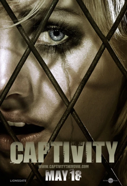 Close-up of a distressed adult female with tears, partially obscured by metal bars. Image promotes the film 'Captivity'.