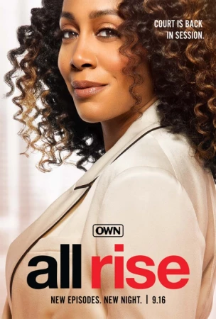 Close-up portrait of a Black woman with long curly hair wearing a cream blazer, photographed by Sheryl Nields.