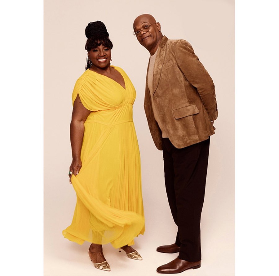 Portrait of a smiling African-American woman in a yellow dress with an African-American man in a brown jacket in a photo studio.