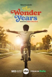 A young Black boy riding a bicycle down a suburban street at sunset with arms outstretched, photographed by Matt Sayles.