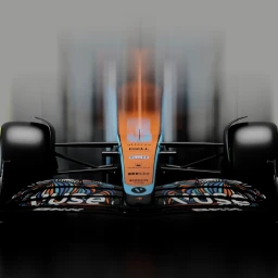 Front view CGI render of a Formula 1 race car with papaya orange and blue livery and patterned front wing against a misty background.