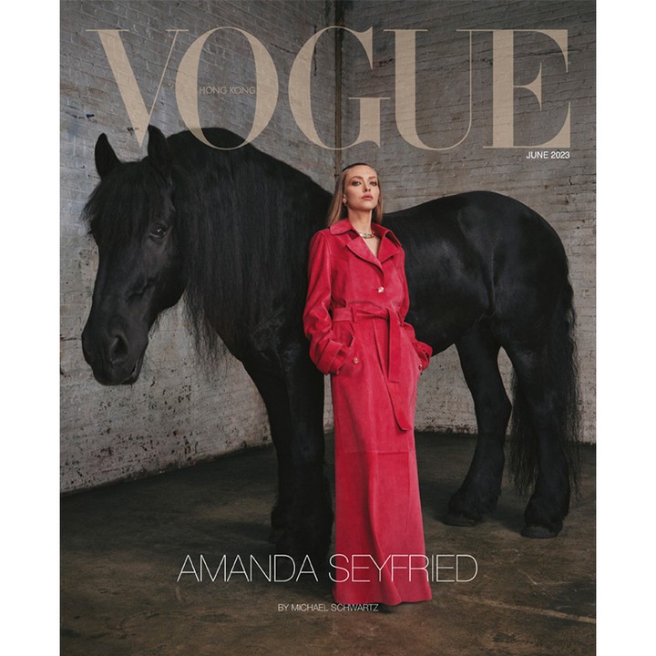 Vogue cover featuring Amanda Seyfried posing beside a black horse against a brick wall background in a photo studio, June 2023.