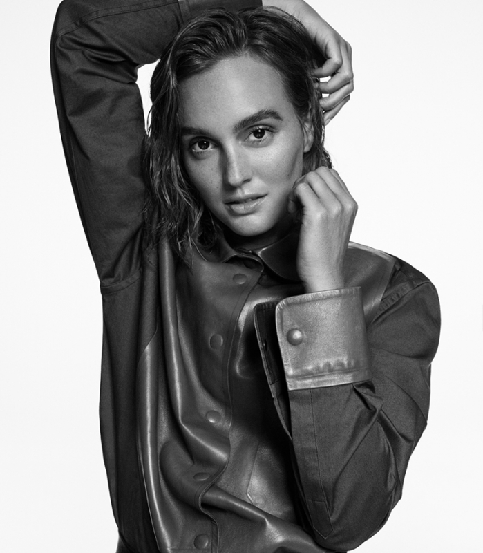 Monochrome portrait of a young adult woman with wet hair wearing a button-down shirt in a light studio setting.
