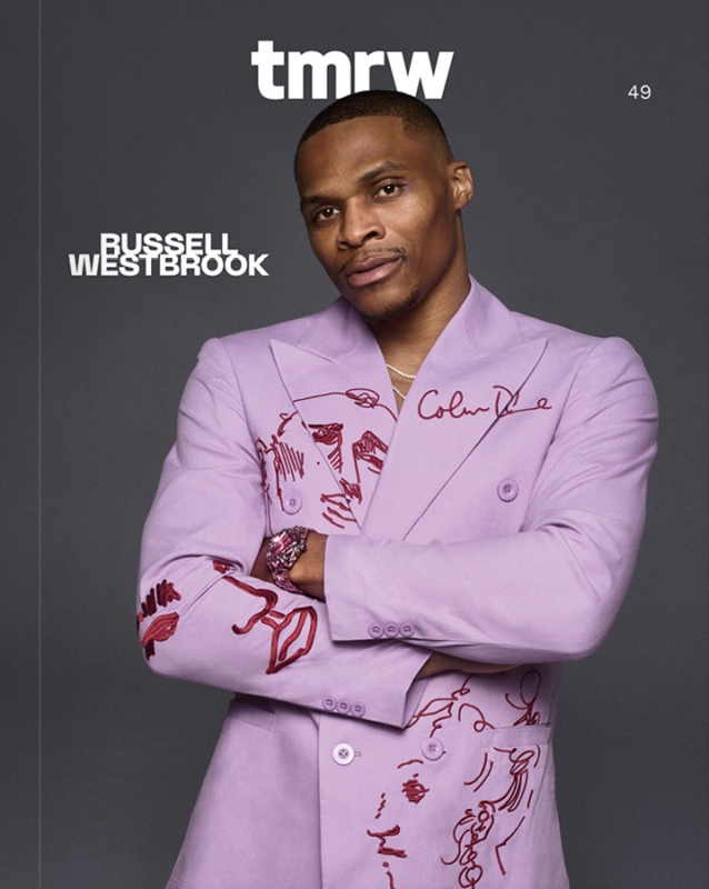 Fashion portrait of Russell Westbrook in a lilac suit with abstract illustrations, posing against a gray background for 'tmrw' magazine.