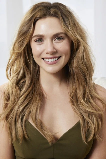Close-up portrait of a smiling woman with long, wavy blonde hair and an olive-green sleeveless top against a bright, neutral background.