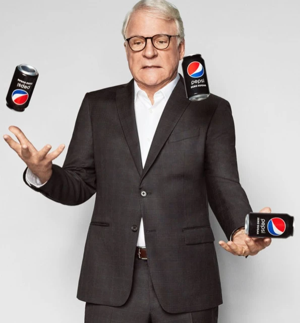 Mature man in a suit juggling three cans of Pepsi Zero Sugar in a bright, neutral studio with a joyful, energetic, and playful mood.