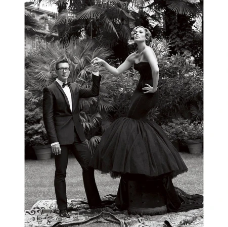 Monochrome fashion portrait featuring a woman in a black strapless gown and a man in a tuxedo standing outdoors.