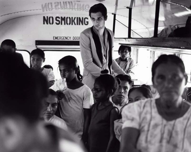 A portrait shows a fair-skinned adult woman with red hair posing indoors with soft lighting and a neutral background.