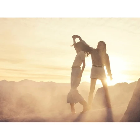 Two women dancing together outdoors in a hazy landscape at sunset captured by Carter Smith