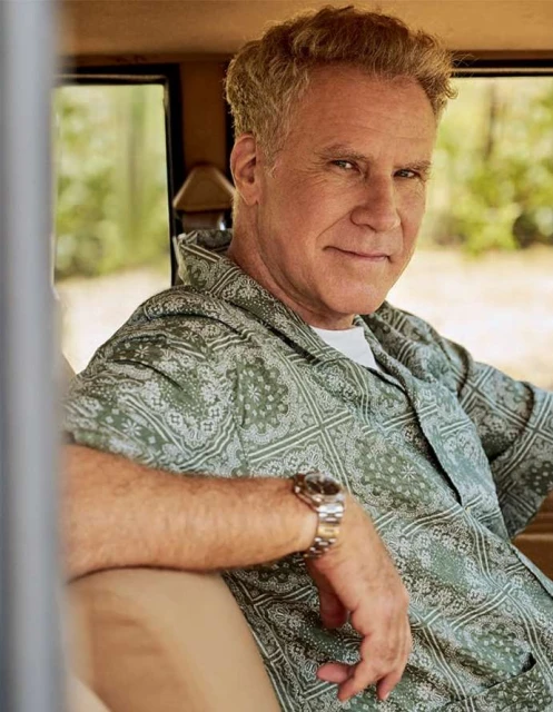 Portrait of Will Ferrell in a car, wearing a patterned green shirt and a watch, smiling at the camera.