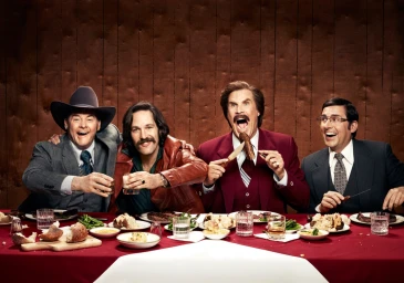 Four men seated at a banquet table dining together, photographed by Justin Stephens.
